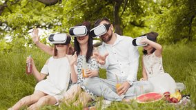 Young caucasian family having fun in virtual glasses on fresh air. Happy parents with two daughters sitting on soft blanket and playing games. Leisure time and entertainment concept. Happy family. - Powered by Shutterstock - Get 15% off with code: PIKWIZARD15