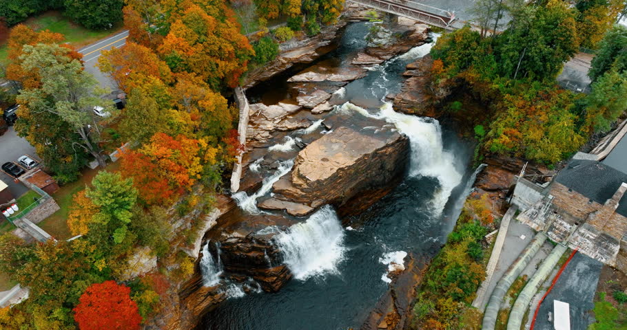 Aerial view on Ausable Chasm waterfall, Adirondack mountains in autumn colors, upstate New York. Hydroelectric power station buildings on the bank of the river.