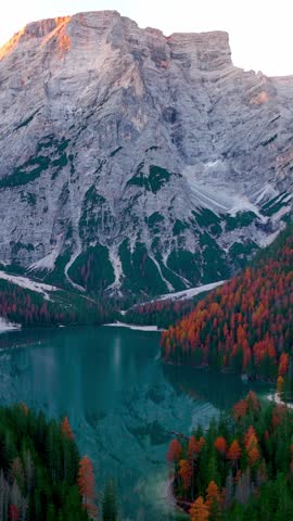 vertical video of autumn lake Braies, Dolomites aerial view, Lago di Braies in Italian Dolomites, sunrise in the Italian Alps, alpine lake in Italy, travel in Italy. High quality FullHD footage
