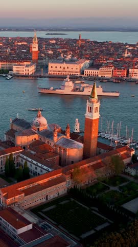 vertical video, drone view of Venice at sunrise, aerial view of Island of San Giorgio in Venice lagoon at dawn, tourism in Venice, Italy. High quality FullHD footage