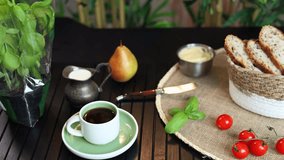Rustic breakfast scene with fresh cherry tomatoes, sliced bread in woven basket, knife with basil leaves on burlap placemat, and cup of coffee in green saucer. Eco-friendly clean food concept. - Powered by Shutterstock - Get 15% off with code: PIKWIZARD15