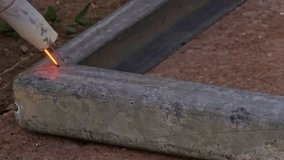 The welding process of steel frame on the ground with cheap Gasless MIG FCAW-S - flux core arc welding-self-shielded device. - Powered by Shutterstock - Get 15% off with code: PIKWIZARD15