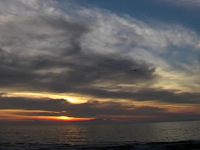 Sunset on the beach with clouds, blue sky and copy space