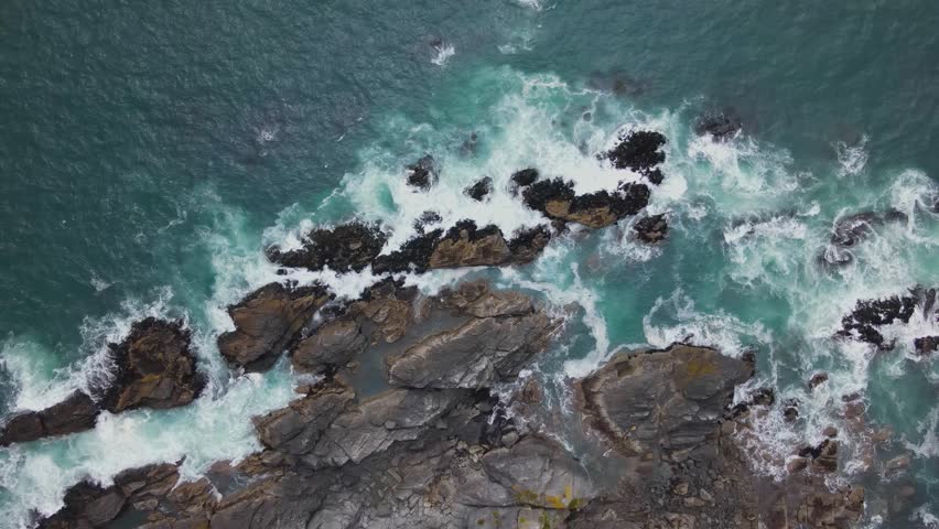 Colorful blue ocean water splashing on rocks 4K 60fps
