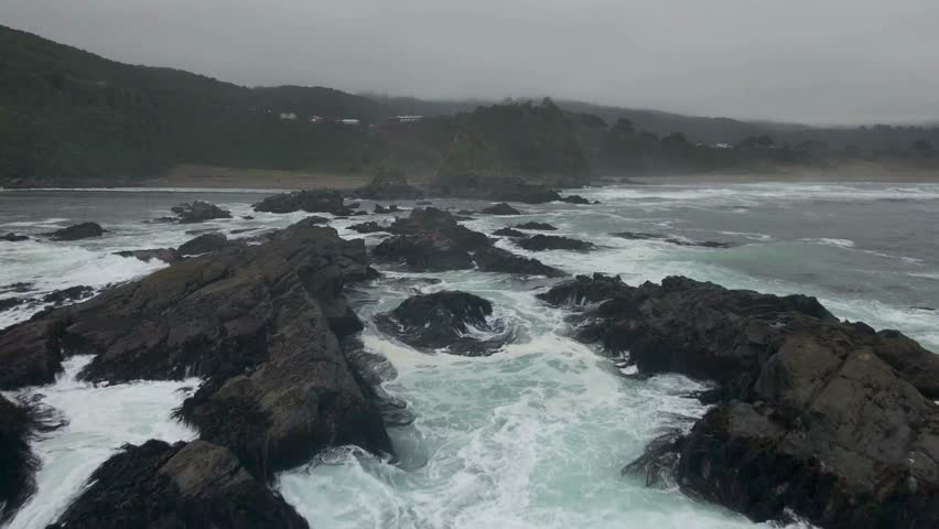 General view splashing water on rocks and beach 4K 60fps
