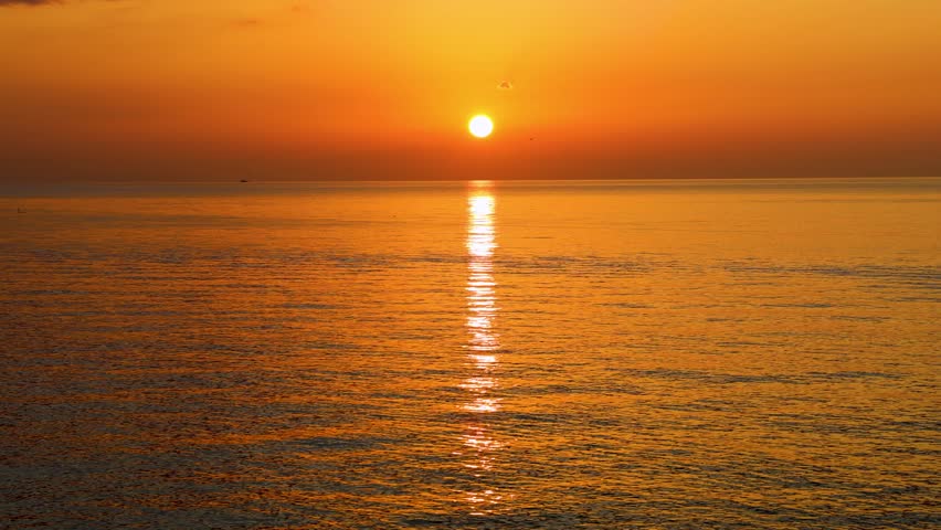 Golden idyllic sunset over the ocean. The evening sun at the golden hour. 