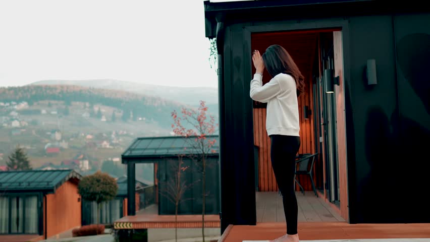 Young woman stands on nails on the terrace near the house early in the morning. Sadhu boards. Nail concept 4k