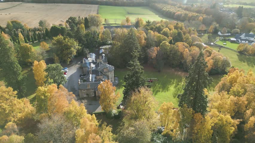 reveals helicopter parked grass luxurious country house estate autumn trees forest background enhance richness property dynamic downward aerial drone shot hotel mansion