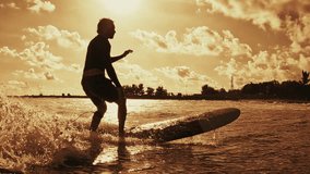 Surfer rides the wave in the Maldives at sunset - Powered by Shutterstock - Get 15% off with code: PIKWIZARD15