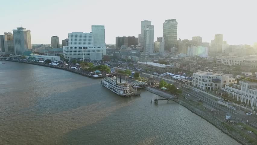 New Orleans Cityscape during French Quarters Music Festival , Louisiana. Mississippi River City Skyline in Background. Sunset Light. Drone