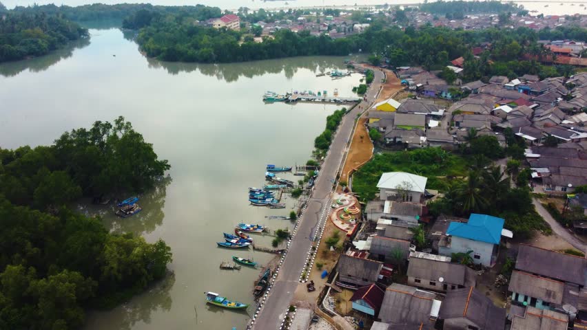 Aerial view of fishing trap net in canel with fisherman urban city village town houses, lake or river. Nature landscape fisheries and fishing tools at Indonesia. Aquaculture farming