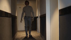 A person walks down a dimly lit hallway with a concerned or anxious expression, glancing upward as if reacting to an unseen presence or sound. The scene creates a suspenseful, mysterious atmosphere. - Powered by Shutterstock - Get 15% off with code: PIKWIZARD15