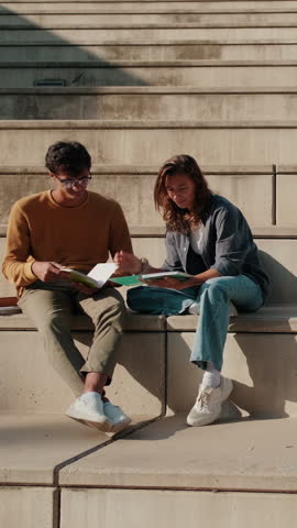 Vertical video, Group of young people smiling and chatting outdoors. Friendship concept with guys and girls talking and socializing hanging out together