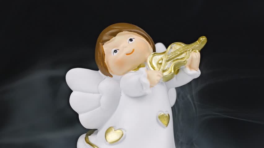 Christmas concept shot with angels playing instruments colored lights with bokeh and fog on the ground