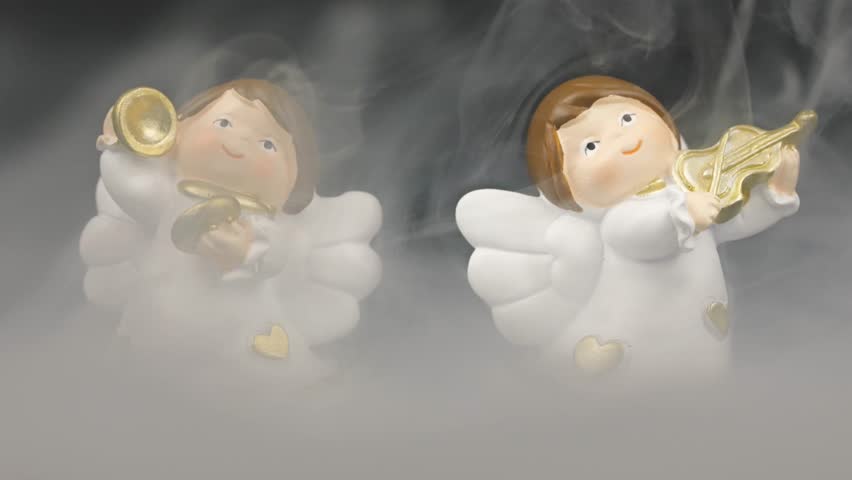 Christmas concept shot with angels playing instruments colored lights with bokeh and fog on the ground