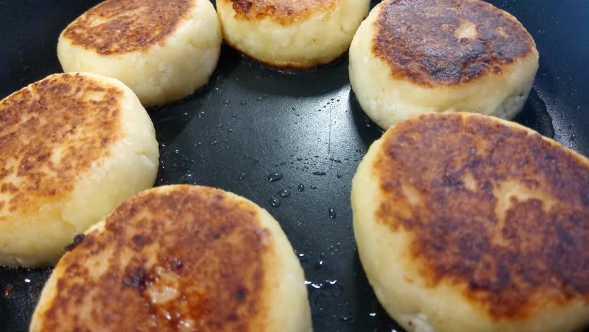 Golden Homemade Cheese Pancakes Frying in a Pan - Perfect Comfort Food for Breakfast