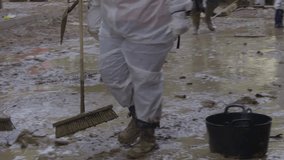 Unrecognizable volunteers cleaning the streets of Valencia in a flood. Natural disaster, floods Valencia, Spain - Powered by Shutterstock - Get 15% off with code: PIKWIZARD15