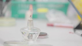 A small glass container with a flame inside of it. The flame is yellow and orange. The container is on a table - Powered by Shutterstock - Get 15% off with code: PIKWIZARD15