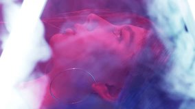 Vertical video. Neon light face. Cyberpunk beauty. Disco 80s nightlife. Pink blue color glow profile of girl in white smoke cloud on dark. - Powered by Shutterstock - Get 15% off with code: PIKWIZARD15