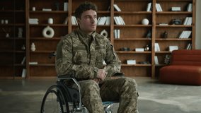 Confused millennial Caucasian male officer in camouflage Ukraine uniform man with disability military army soldier serious guy veteran in wheelchair looking distance healthcare problem in office room - Powered by Shutterstock - Get 15% off with code: PIKWIZARD15