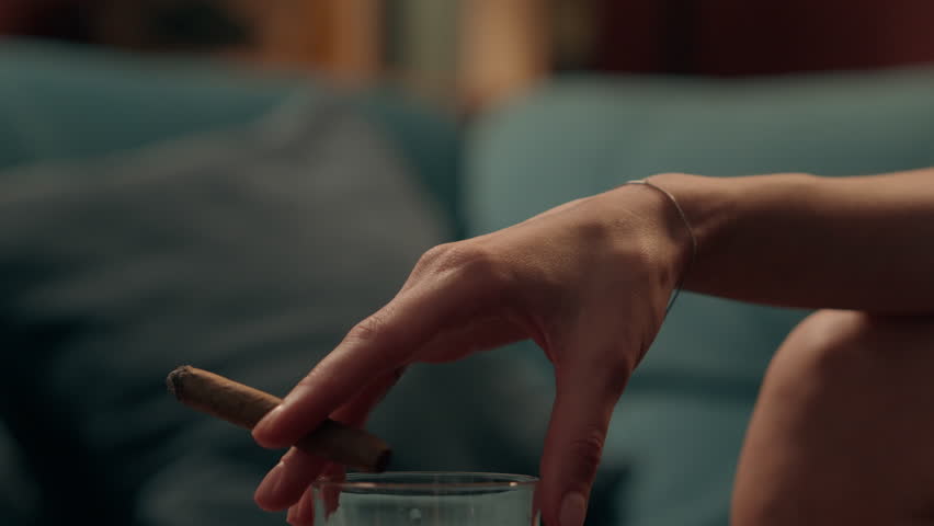 Close up unrecognizable Caucasian woman girl female hand holding cigar and glass alcohol drink addiction bad habit depression mental health problems smoking unhealthy lifestyle indoor home night room