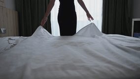 Unrecognizable woman making bed in hotel room. Maid cleaning room. Hotel room service. - Powered by Shutterstock - Get 15% off with code: PIKWIZARD15
