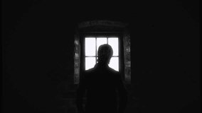 Confined Solitary Man Looking Window Vintage Film Zoom In. Silhouette of a solitary figure inside a dark eerie room looking through the window. Zoom in - Powered by Shutterstock - Get 15% off with code: PIKWIZARD15