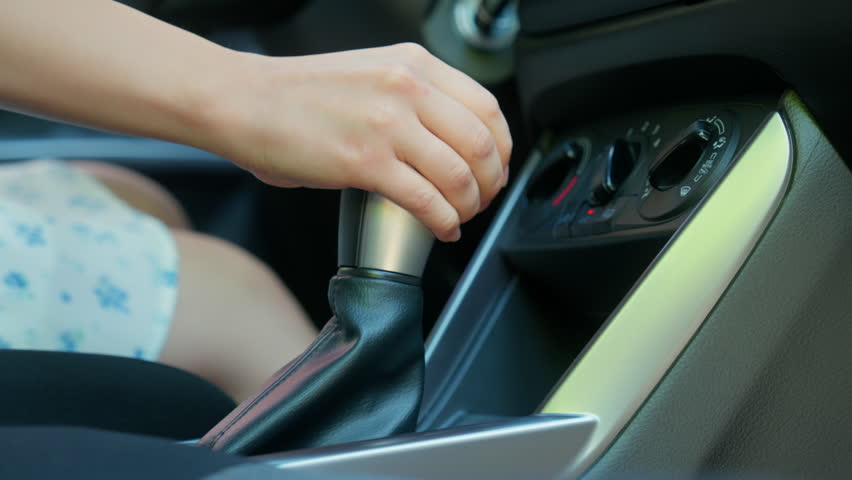 Close up unrecognizable Caucasian woman girl car buyer automobile driver female hand shifting changing gears manual transmission gear stick control gearbox driving inside auto buying new vehicle rent