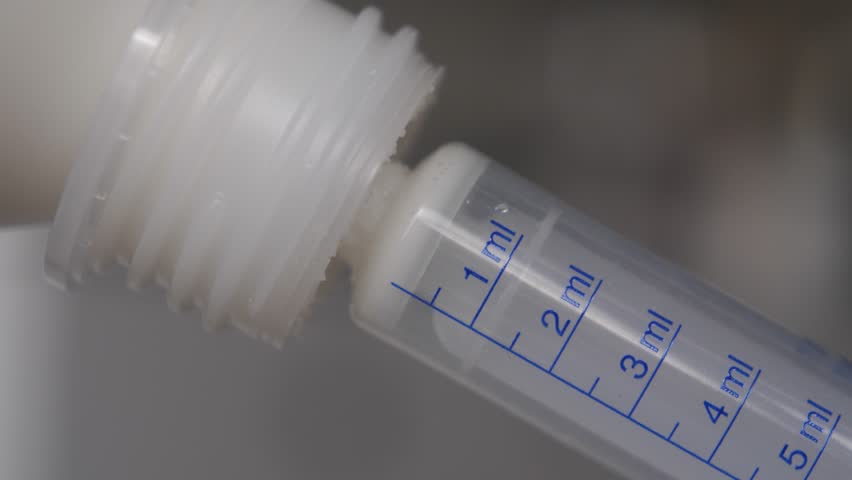 Close up of measuring antibiotics dosage with a transparent syringe