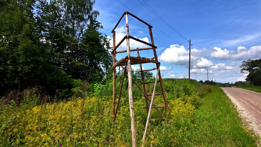Abandoned lookout post on the side of a road in the village with trees and thick bushes on the sides