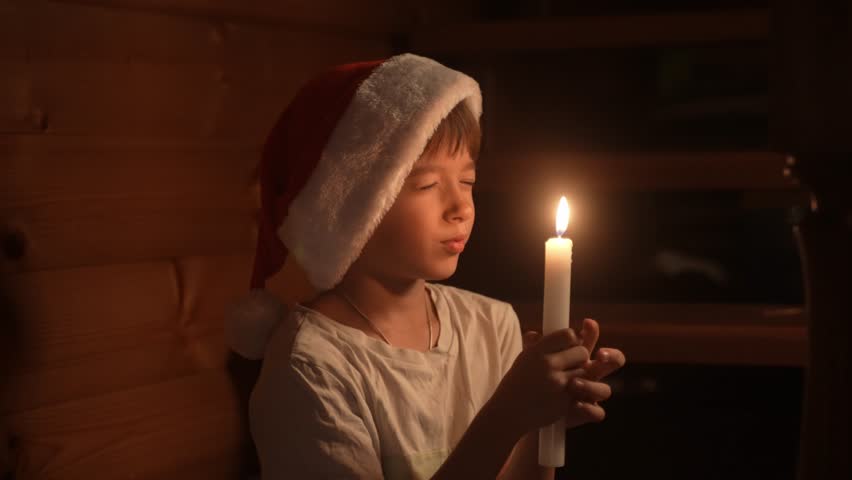 Young boy holding a burning candle making a wish