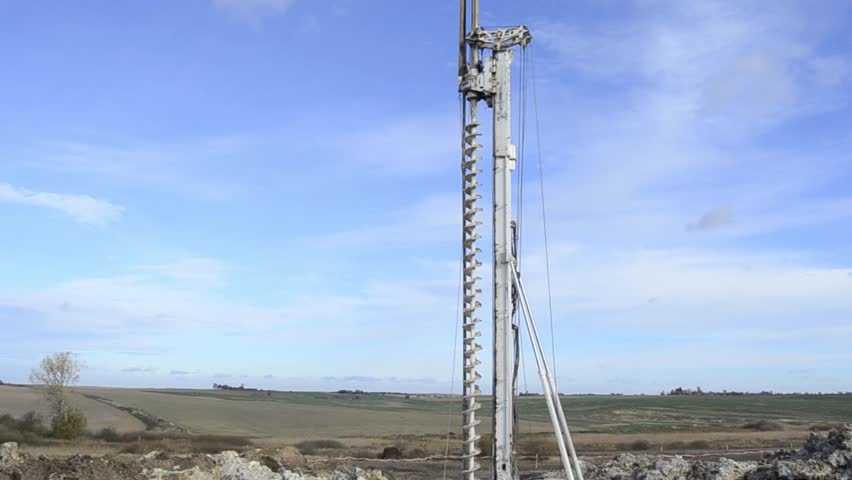 Building activity on contruction site.Drilling machine.Wind turbine construction. Excavator and other construction equipment.