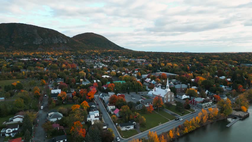 aerial circular shot revealing Mont Saint Hilaire landscape and town in Quebec province near Montreal City during fall season in Canada