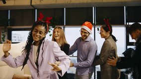 A multiracial group of business colleagues celebrates the New Year with dancing and joy at a festive office party, sharing laughter and holiday cheer. - Powered by Shutterstock - Get 15% off with code: PIKWIZARD15