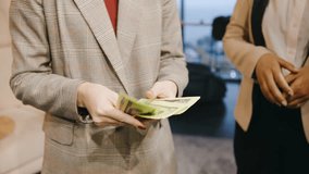 Close up of a business professionals hands holding and distributing cash, symbolizing corporate success, teamwork, and financial achievement - Powered by Shutterstock - Get 15% off with code: PIKWIZARD15