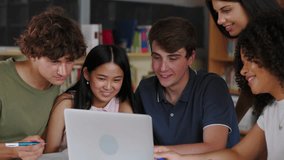 Young multiracial group of high school students working together on laptop at library. Education and youth lifestyle concept. - Powered by Shutterstock - Get 15% off with code: PIKWIZARD15