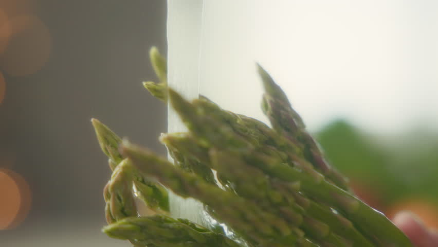 Water splashing over asparagus in the kitchen sink. Slow motion.  - Powered by Shutterstock - Get 15% off with code: PIKWIZARD15