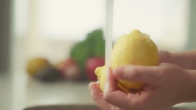 Close up of woman's hands washing yellow lemons under tap water. Slow motion. - Powered by Shutterstock - Get 15% off with code: PIKWIZARD15