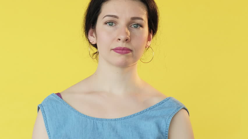 So-so gesture. Skeptical expression. Woman not sure dont know signaling uncertainty double feeling with hand movement facial expression isolated on yellow free space background.