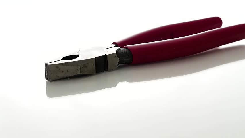 Red pliers rotating on a display table.