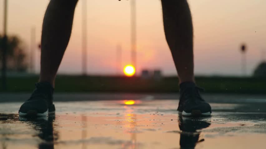 people playing basket ball game with sunset background. men playing basketball on outdoor court at dusk. basketball players at the beautiful sunset.