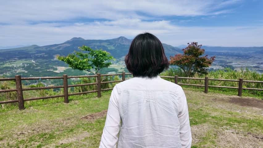 A woman looking at the natural scenery from an observation deck