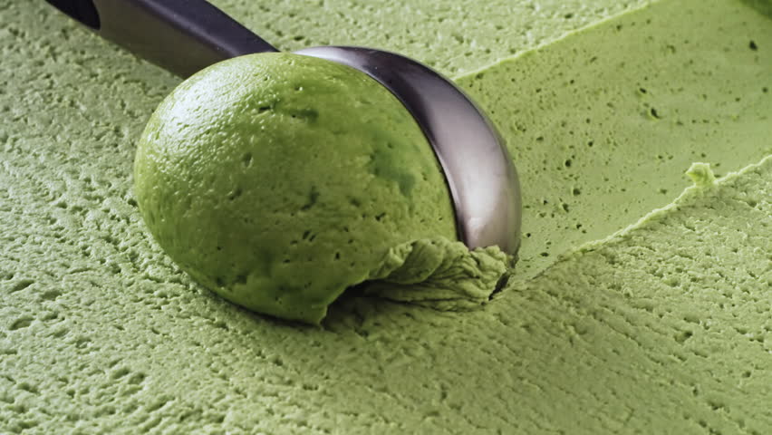 close up following shot of pistachio or mint flavored green ice cream scooping in slow motion
