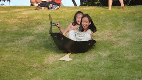 Children are playing on a slide on a grassy hill in a park. Happy active kids playing outdoors during the summer. - Powered by Shutterstock - Get 15% off with code: PIKWIZARD15