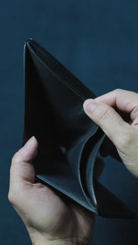 Businessman showing an empty wallet, highlighting financial struggles and the absence of money