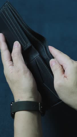 Man displays an empty wallet, highlighting financial struggles and the impact of economic challenges