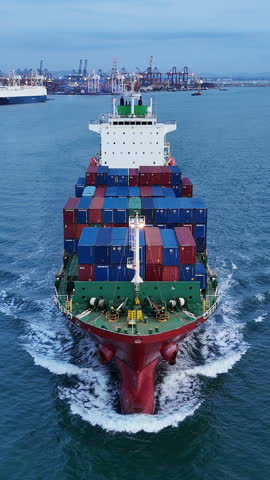 Portrait Front view of Cargo container ship carrying container and running out from international container port customs shipyard sea port concept smart logistic service. Container Ship freight export
