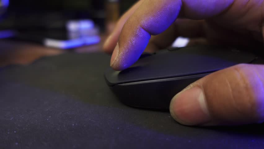 Click black computer mouse on a work desk. Click and scrolling computer mouse. A male hand holding a computer mouse.