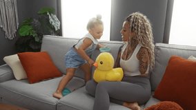 Mother and daughter enjoy playful bonding with a toy duck in a cozy living room, surrounded by soft cushions, sharing laughter and love in a warm indoor setting. - Powered by Shutterstock - Get 15% off with code: PIKWIZARD15