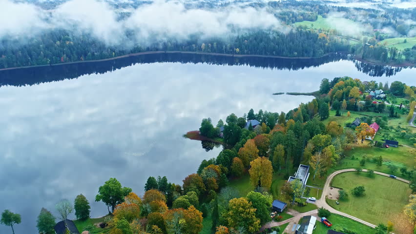 Aerial view of Mists above Lake with Forested Shoreline and Autumn Colors